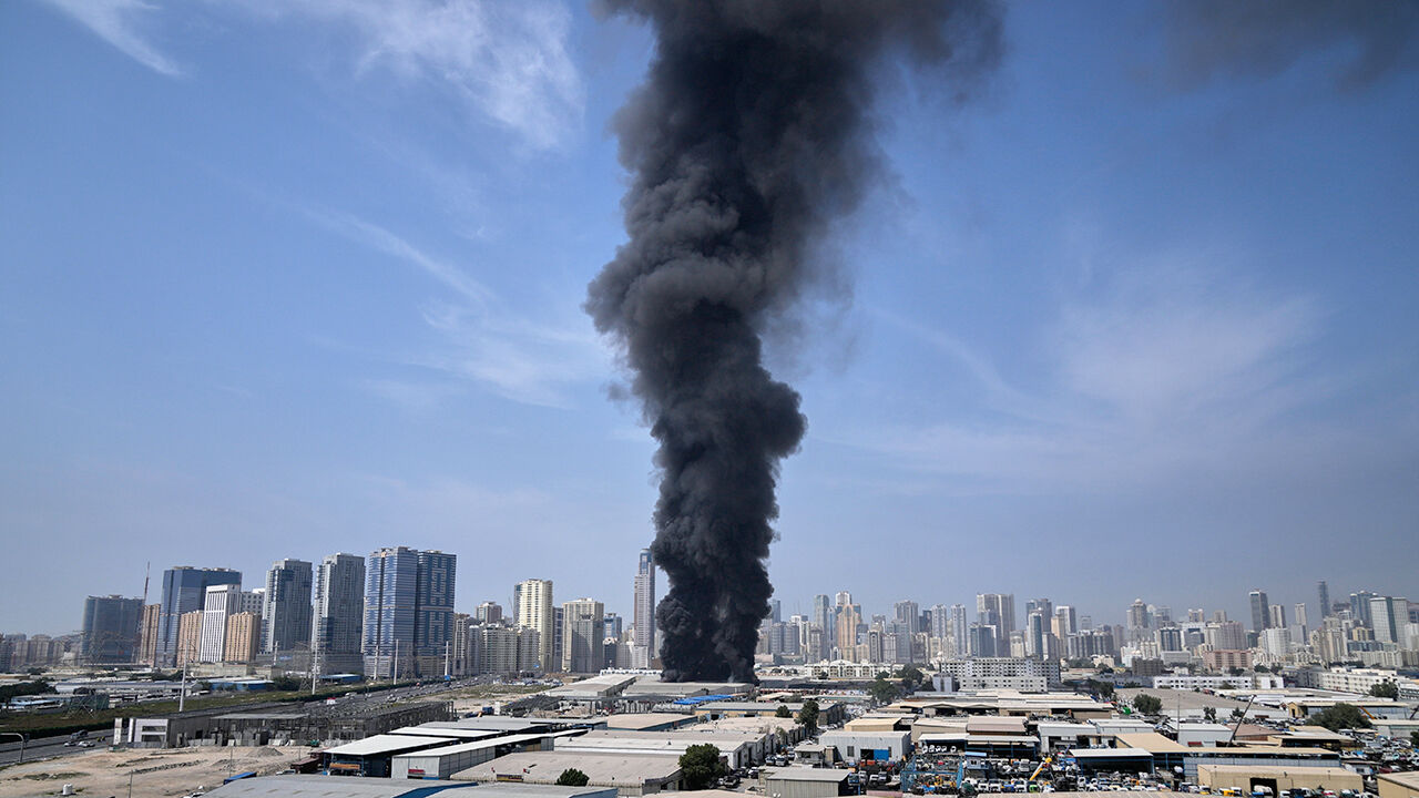 A black plume of smoke rises from a warehouse at the industrial area of Sharjah City in the United Arab Emirates