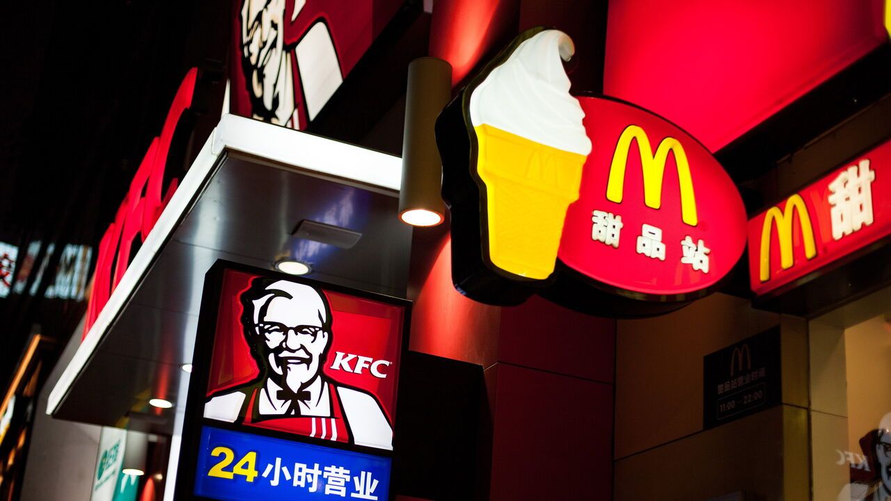 An illuminated sign of the McDonald's fast food chain and KFC in a street in Shenzhen, China