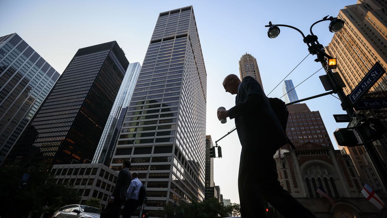 Pedestrians walking in the foreground of the Blackstone headquarters at 345 Park Avenue in New York, USA.
